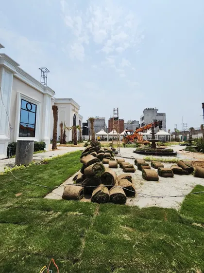 Rolls of fresh turf are laid out and ready for installation across a large venue space, showcasing the scale of our commercial landscaping projects.