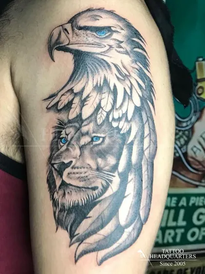 A powerful composite tattoo merging the faces of a lion and an eagle, both with striking blue eyes. This piece symbolizes strength, vision, and freedom.