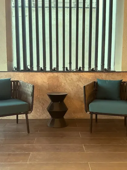 The clean lines of the furniture and the slatted privacy screen create a modern and sophisticated outdoor lounge area.