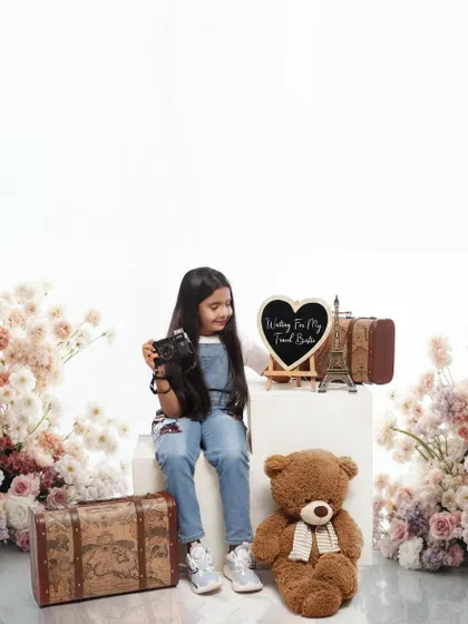 A beautifully styled sibling announcement shoot, where the big sister waits for her 'travel buddy' surrounded by vintage suitcases and flowers.