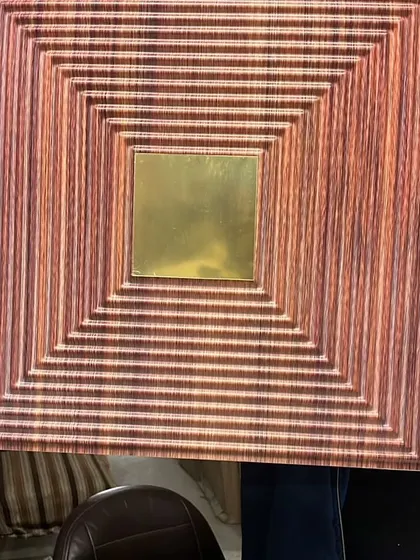 This PVC panel features a wood-grain finish with grooved squares and a central gold mirror. It's a great way to add warmth and modern texture to a space.