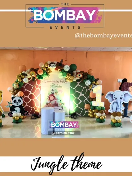 A full view of a jungle-themed birthday setup featuring a triple backdrop with giraffe prints. The scene is completed with character cutouts of a tiger, panda, elephant, and giraffe.