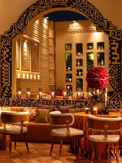 A seating nook from the 'Mid-Century Mod' event, showcasing hand-painted tribal patterns on the archway and textured fabrics. The monotone color palette was enriched with an abundance of textures and artisanal details.