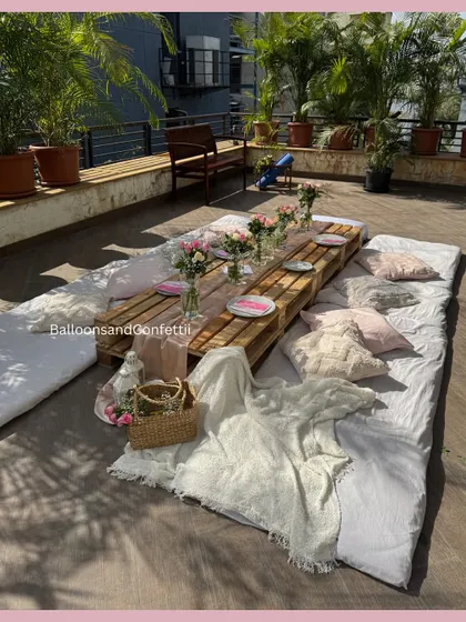 A wider angle of our rooftop boho picnic. You can see the full arrangement of mattresses, cushions, and throws that create a relaxed and inviting atmosphere for guests.
