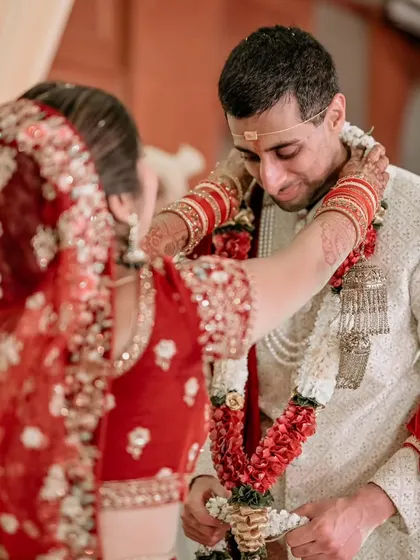 The bride places the garland on her groom during the varmala ceremony, a key moment filled with joy and tradition.
