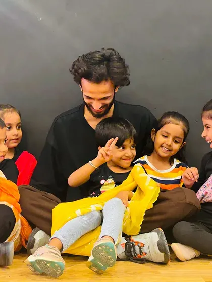 The joy of learning together. Our instructors are always right there with the kids, guiding them with a smile. This picture captures the supportive spirit of our Little Groovers class.