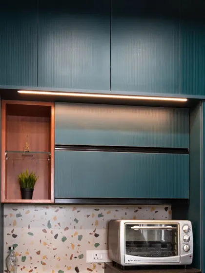 Under-cabinet lighting in this kitchen provides excellent task lighting over the countertop and highlights the terrazzo-style backsplash.