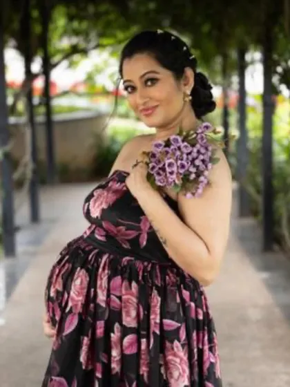 A beautiful close-up of a client wearing our black floral gown for her maternity shoot. The off-shoulder design is both elegant and flattering.