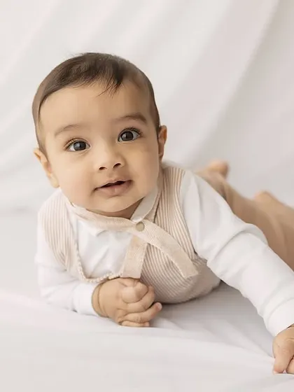 A calm, direct gaze. This portrait captures a quiet moment amidst the playful energy of a six-month session.