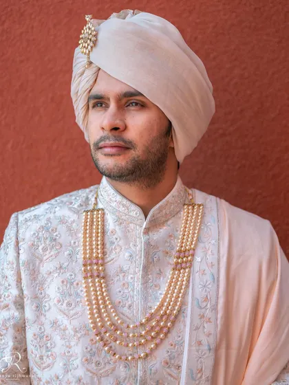 A handsome portrait of the groom in his wedding sherwani, looking sharp against the golden hour light.