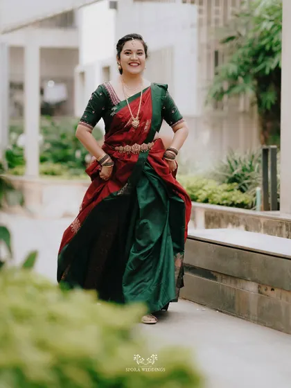 The bride's happiness is infectious in this shot, as she walks forward in her beautiful red and green half saree.