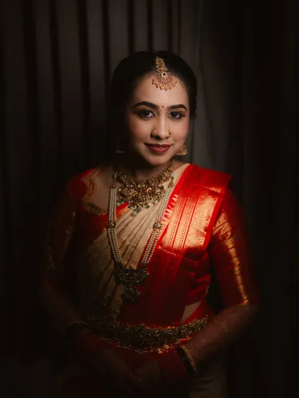 A classic portrait with dramatic lighting. The bride's makeup, especially her bold lip and defined eyes, stands out beautifully.