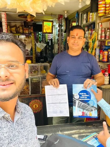 Our team member takes a selfie with a customer holding his solar agreement.