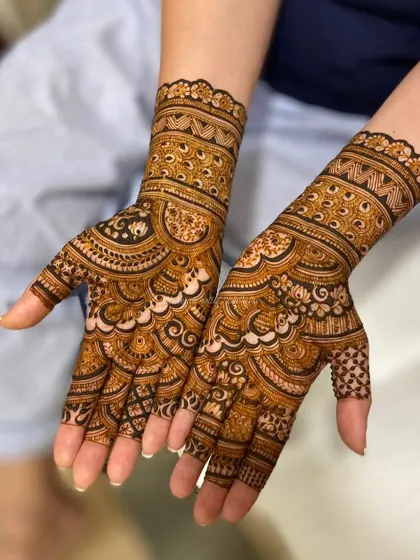 A gorgeous bridal design with scalloped edges and dense, flowing patterns that cover the hands beautifully.