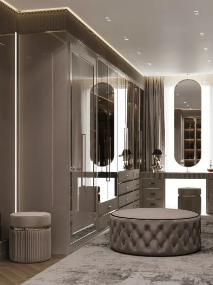 The sleek design of this dark-toned closet is emphasized by the reflective surfaces and clean lines. The dual vanity stations with large, oblong mirrors add a touch of modern glamour.