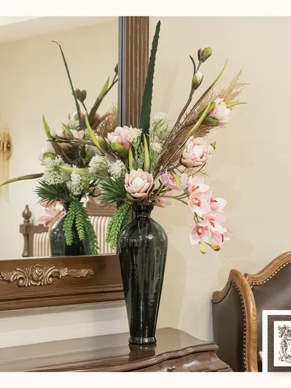 This lush floral arrangement in a dark, modern vase creates a beautiful contrast against the ornate wooden console and mirror. It's a perfect example of blending classic and contemporary styles.