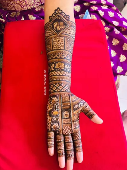 A single-hand view of a bridal design, showing a mix of popular motifs. You can see an elephant in a checkered box at the top, with lotus and peacock figures woven into the pattern below.