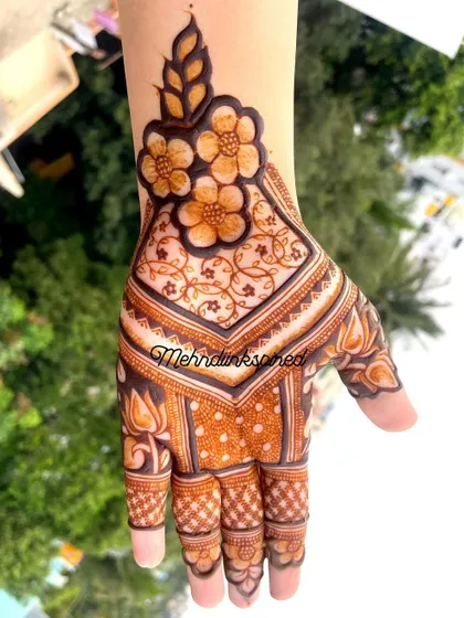 This minimal design is both full and light. It covers the hand with a beautiful floral pattern at the wrist and a checkerboard fill, while leaving space for the design to breathe.