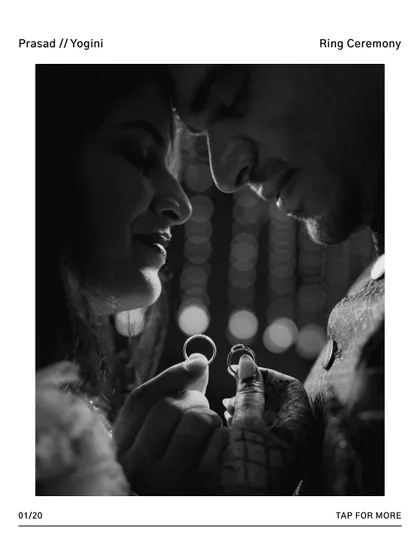 A creative black and white shot of the couple holding their engagement rings between them, their faces close together.