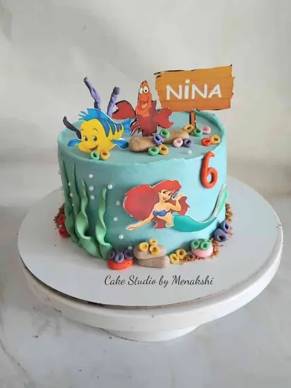 An underwater adventure with this Little Mermaid themed cake. The design features Ariel, Flounder, and Sebastian, surrounded by seaweed and coral details.