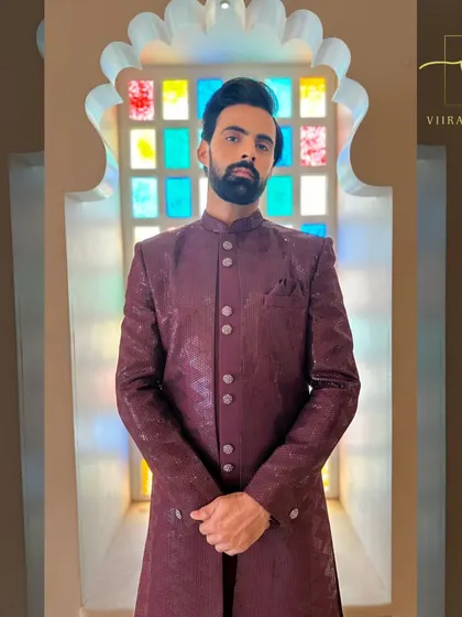 A groom wearing our custom maroon textured sherwani. This rich color is a fantastic choice for wedding ceremonies and receptions.