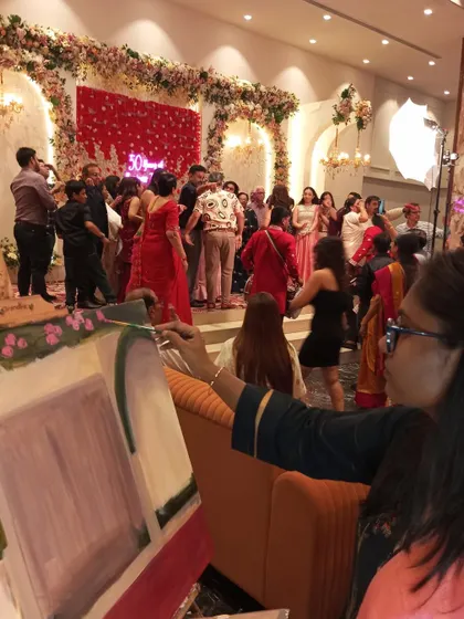 Painting amidst the celebration is what makes it 'live'. Here, you can see me working on the canvas while the anniversary party is in full swing on the stage behind me.