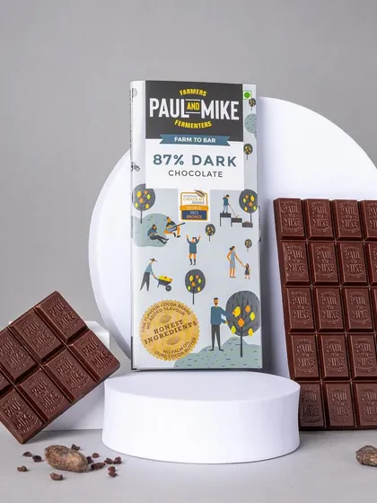 An 87% dark chocolate bar, creatively styled with broken pieces to show the texture and snap of the chocolate.