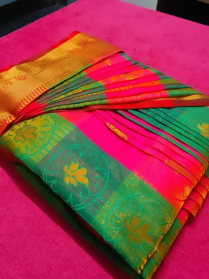Another look at the beautifully folded pink and green saree. The colors and pleats are perfectly preserved, ready for the client to look their best.