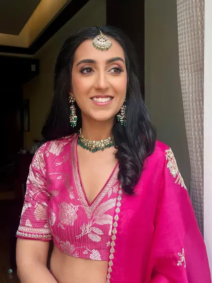 This is what I would call my signature mehendi makeup. A bright pink outfit, glowing skin, and a half-tie hairstyle create a look that is fresh, fun, and festive.