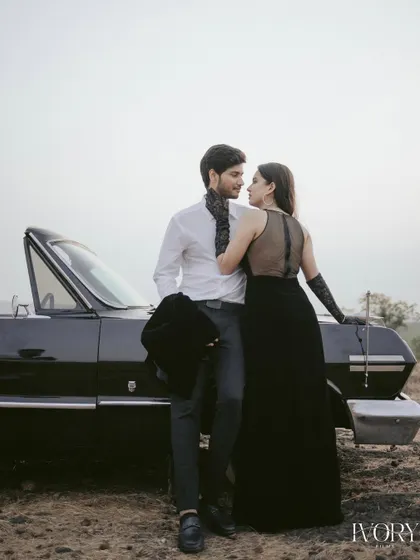 Elegance and intimacy define this moment from a vintage-themed shoot in Goa. Posed against a classic convertible, the couple shares a quiet look, captured in soft light to highlight their connection and the timeless glamour of the setting.