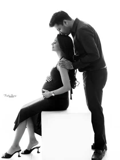 This black and white portrait emphasizes the tender connection between the couple. The simple, clean background keeps the focus entirely on their emotions.