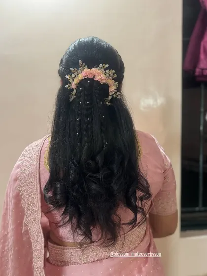 For this unique hairstyle, we combined crimped texture with multiple small braids. The look is finished with a beautiful pink floral hairpiece, creating a very detailed and eye-catching style.