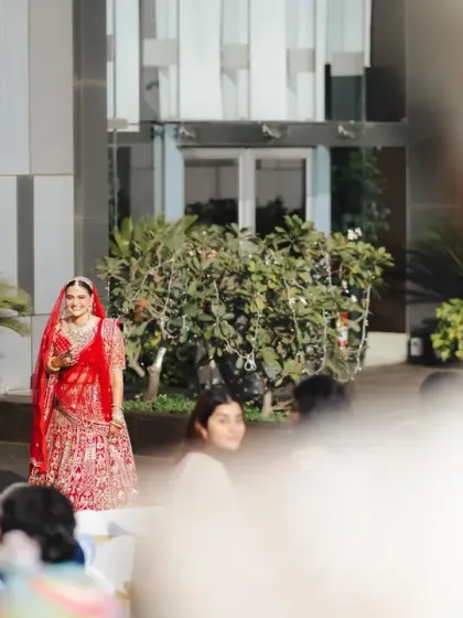 The bride's first look from the groom's perspective. This over-the-shoulder shot captures her walking towards him, her face full of love and anticipation.