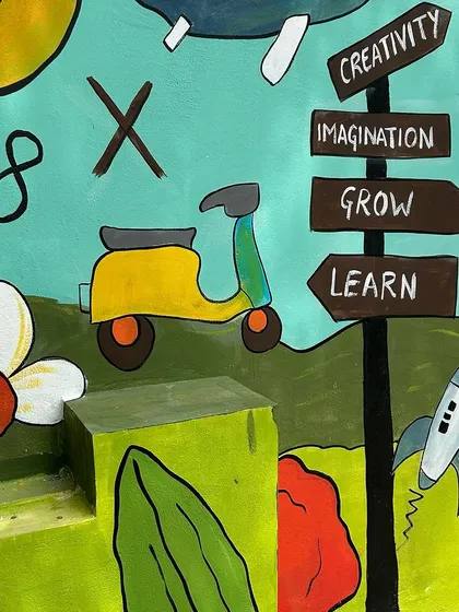 A scooter and a rocket ship add a sense of adventure and movement to this section of the educational mural.