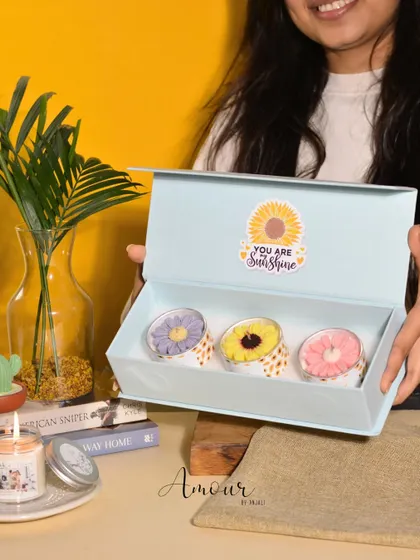 Brighten someone's day with The Sunshine Trio. This image shows me holding the Sunflower Gift Box, which includes three beautiful sunflower candles in jasmine, rose, and lavender fragrances.