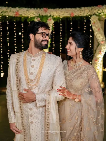 A happy, classic portrait of the couple at their elegant evening reception, surrounded by fairy lights.