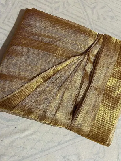 The shimmer of this tissue silk saree is captured beautifully in its neat pleats. I handle delicate fabrics like this with the utmost care.