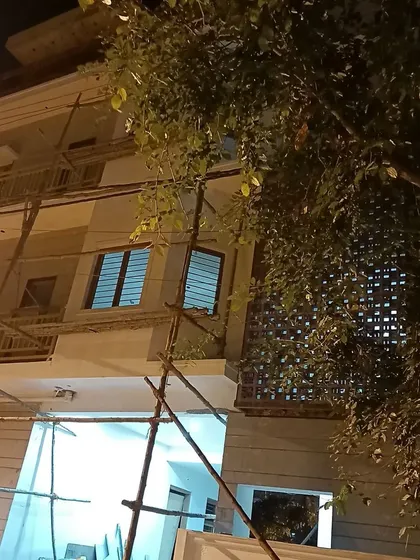This image captures the building's form at night during construction. It shows the raw concrete and blockwork, the essential skeleton of the building that I oversee.
