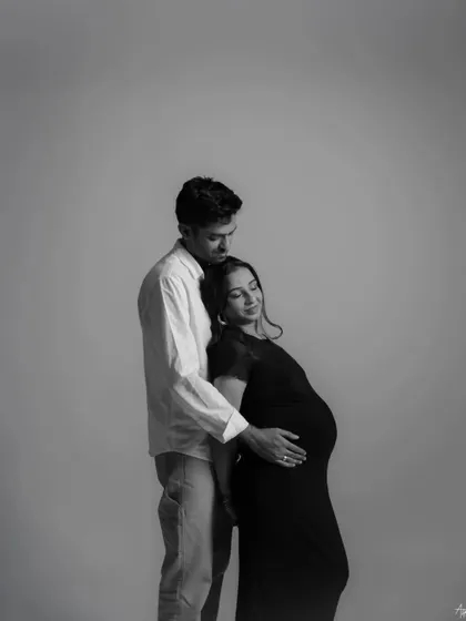A quiet, intimate embrace captured in a black and white portrait. This image focuses on the emotional connection and the feeling of safety and love between the couple.