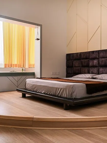 This bedroom features a unique circular wooden platform to elevate the bed, creating a distinct zone within the room. I also enclosed the balcony to create a spacious window seat and study area.