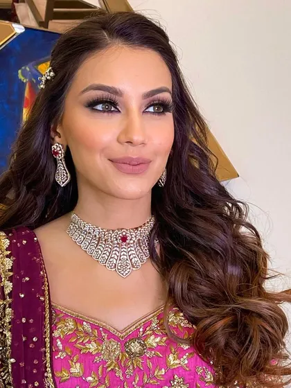 The bride looks stunning with her smokey eye makeup and voluminous, wavy hair.