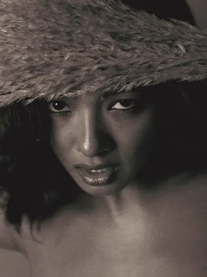 A strong, confrontational gaze from below. This angle, combined with the dramatic shadows of the black and white treatment, creates a powerful and commanding portrait.