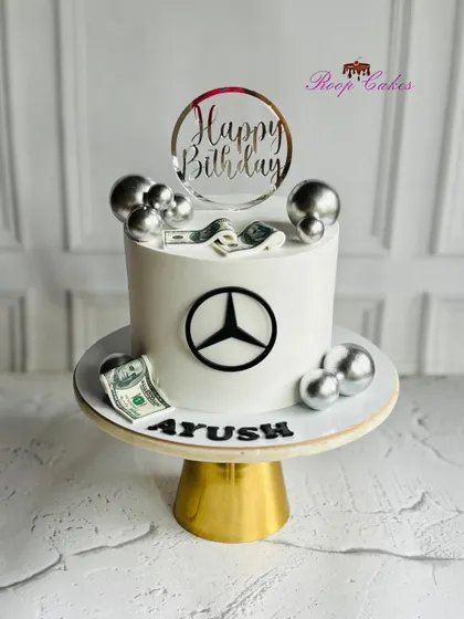 A classy cake for a classy celebration. This Mercedes-themed cake is perfect for a car lover, featuring the iconic logo and silver accents.
