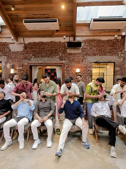 The men having a blast with a 'drink the baby bottle' game at a baby shower. The laughter is contagious!