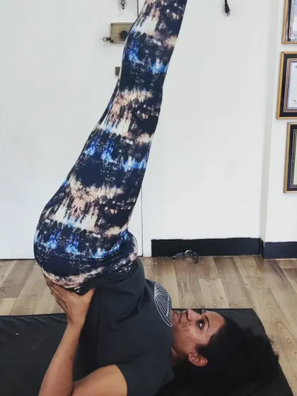 A student practices Sarvangasana, or the shoulder stand, with careful support. As a teacher, I believe in my students' potential even when they doubt themselves, and my role is to encourage them to move beyond their fears and discover their hidden strengths.