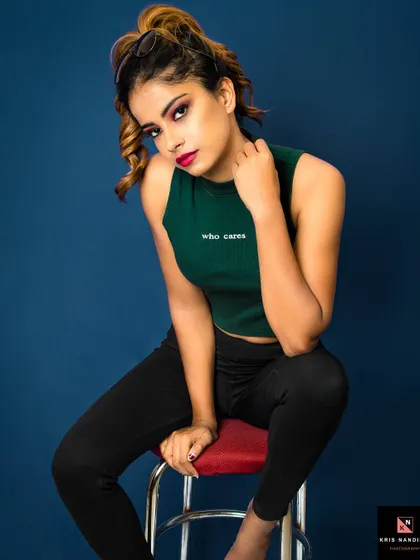 Attitude is everything. This studio portrait uses a bold blue background and strong lighting to highlight the model's confident expression and the "who cares" text on her top, capturing a bold and unapologetic vibe.