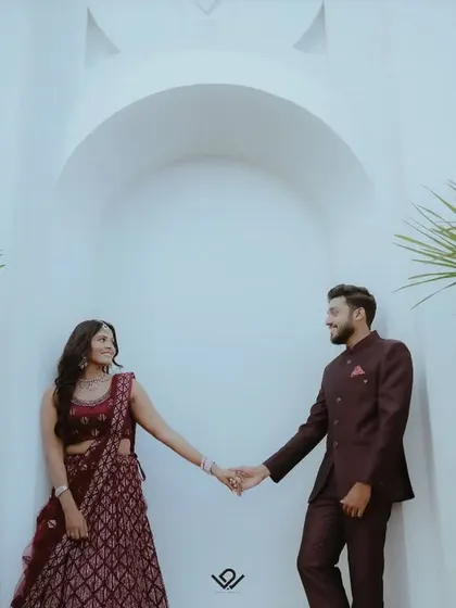 A stylish engagement shoot against a white architectural backdrop, with the couple holding hands.