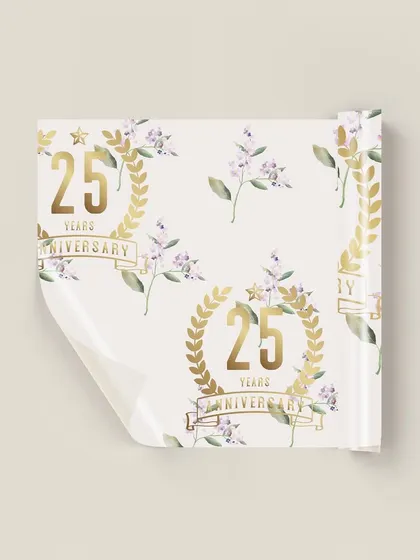 A closer view of the custom 25th anniversary gift wrap. The repeating pattern of the golden anniversary crest and soft lilac florals creates a beautiful and cohesive look for all the event's gifts.