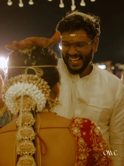 A joyful moment as the groom smiles during the Talambralu ceremony, with rice grains showering down.