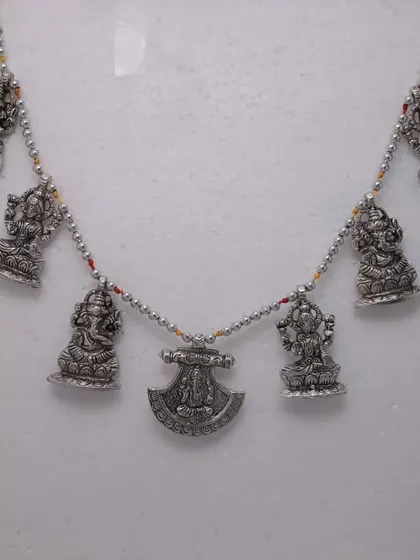 A German silver door hanging (toran) with small idols of Ganesha and Lakshmi, perfect for welcoming positive energy into your home.
